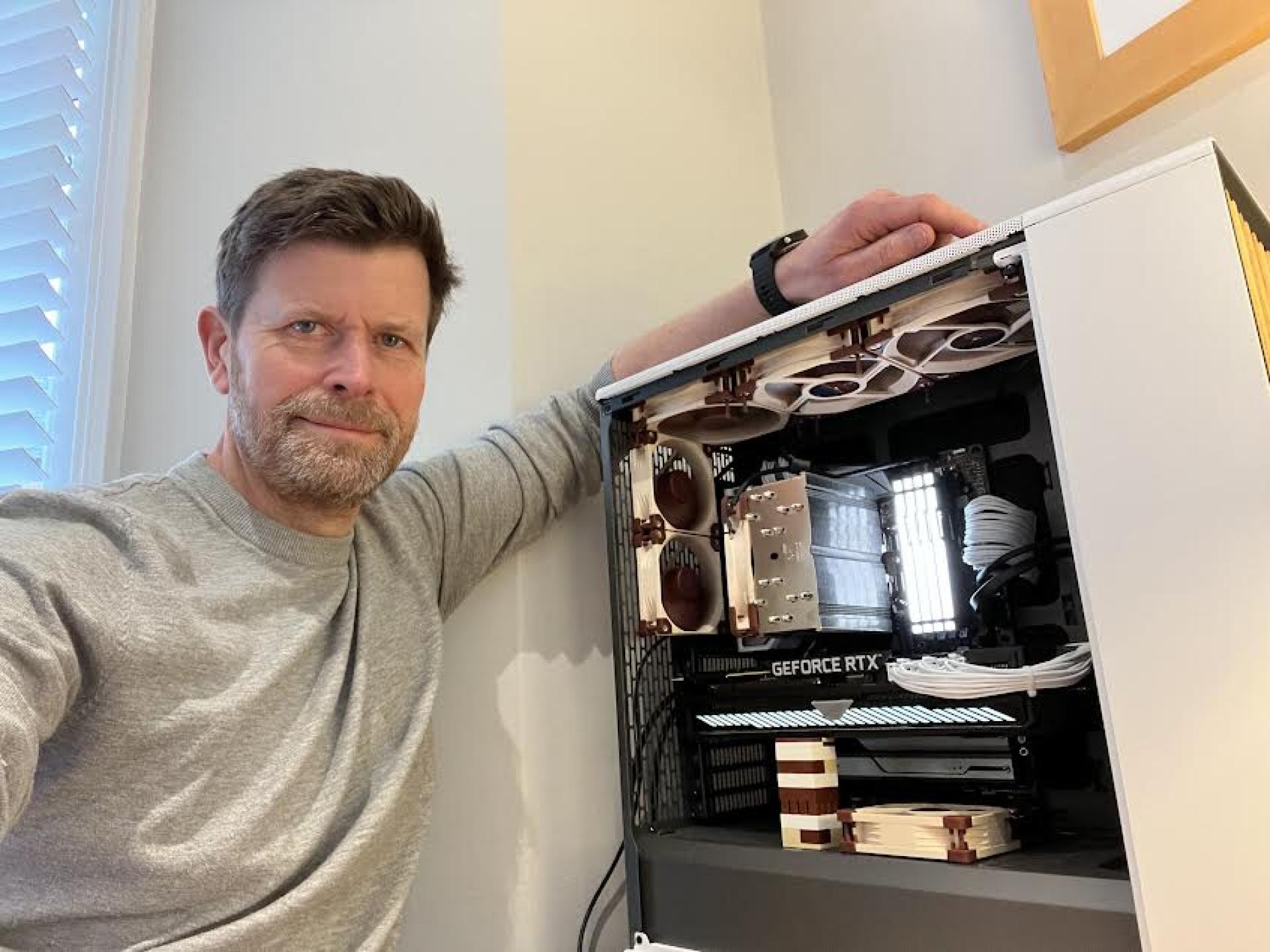 David Bishop standing beside an open desktop computer used for Council Insight analysis