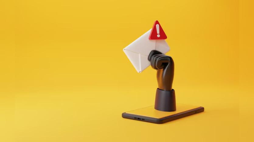 A hacker's hand holding envelope with spam icon on it