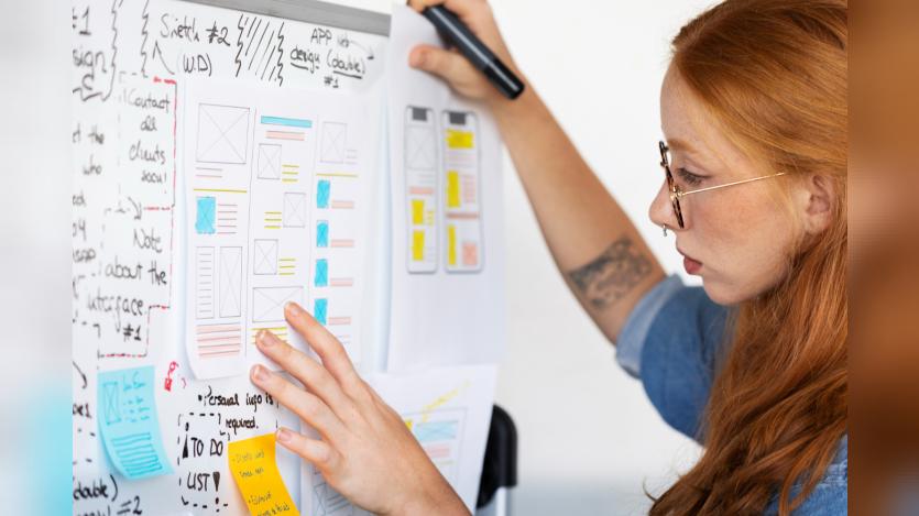 Female web designer with papers and notes in the office
