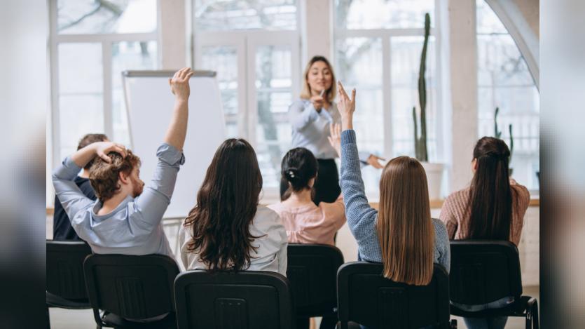 Female speaker giving presentation in hall at university workshop.