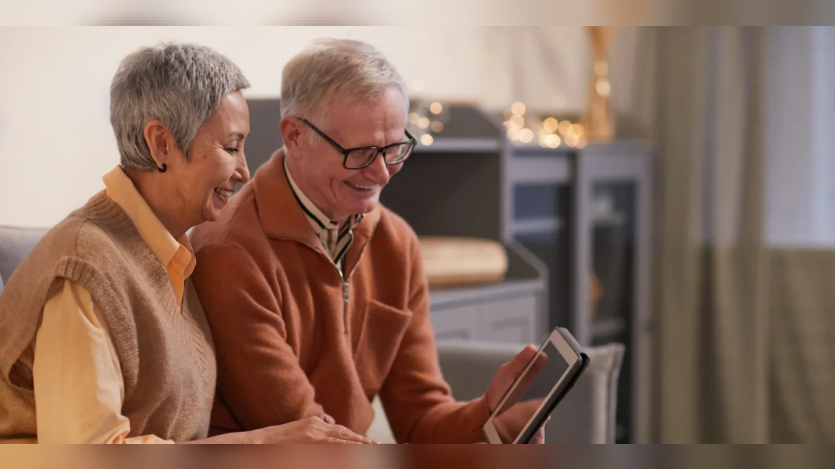 an old couple looking at an ipad