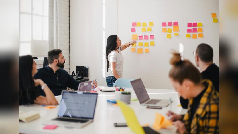 Woman pointing at sticky notes on the board