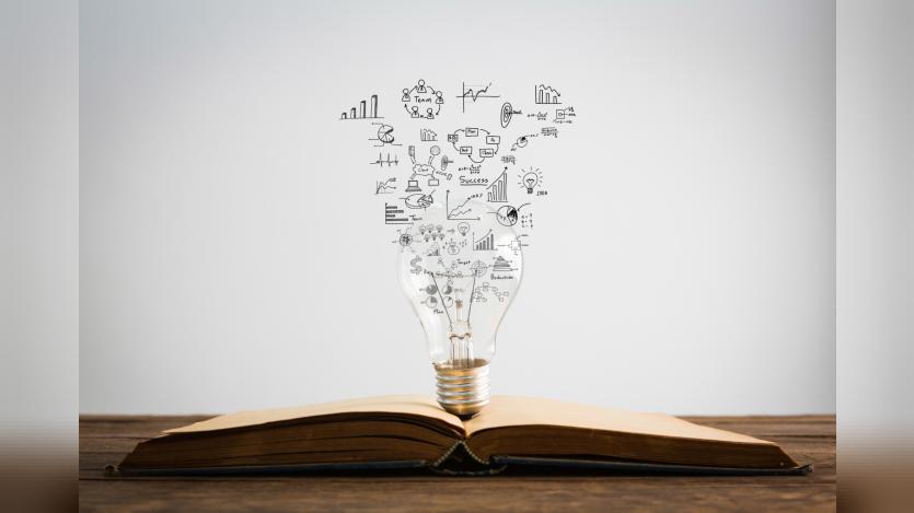 Symbols come out of a bulb on top of a book