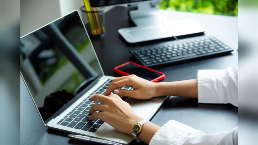 Female hand typing on keyboard of laptop