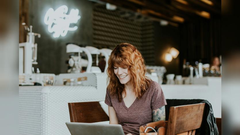 happy woman sitting infront of a laptop