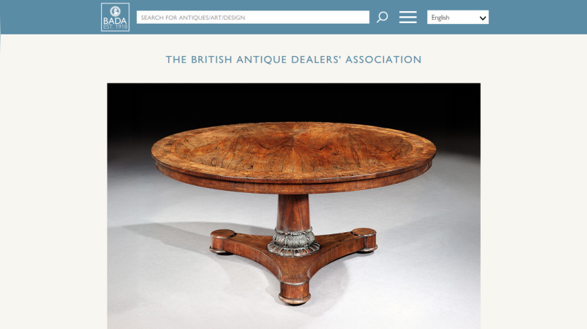 British Antique Dealers' Association homepage with search bar and a round wooden antique table featured