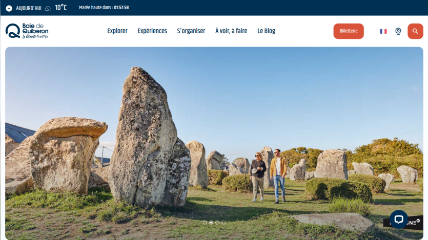 Tourism website header with navigation and hero image of people walking among large standing stones in Baie de Quiberon