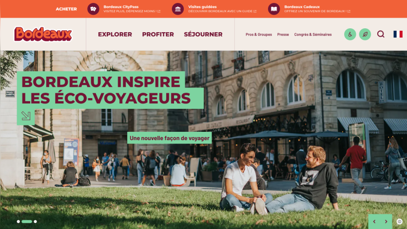 Tourism website promoting Bordeaux as an eco-friendly travel destination with people relaxing on grass in city square