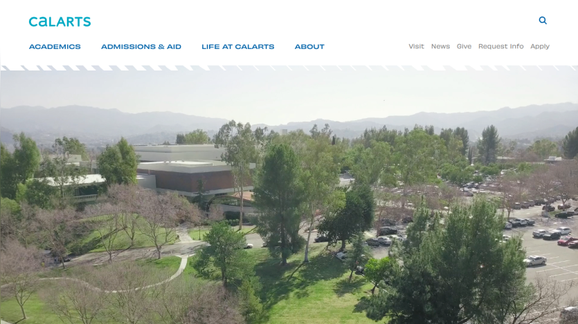 Overview of the CalArts campus with trees and parking area in view.