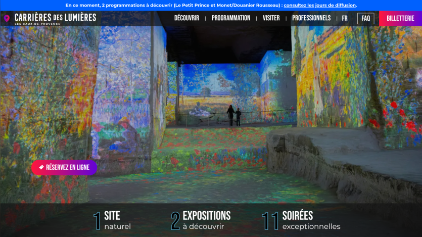 Carrières des Lumières website with colorful immersive art projections and navigation menu in French