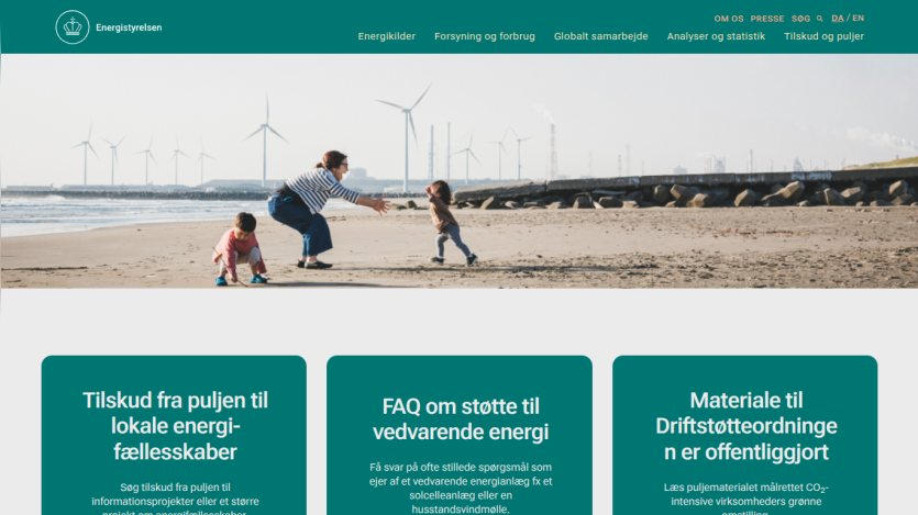 Website promoting local energy initiatives with a family on the beach and wind turbines in the background.