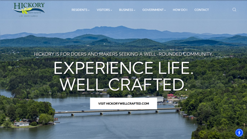 Hickory North Carolina city website with navigation and a hero image of a lake and mountains, featuring the slogan Experience Life. Well Crafted.