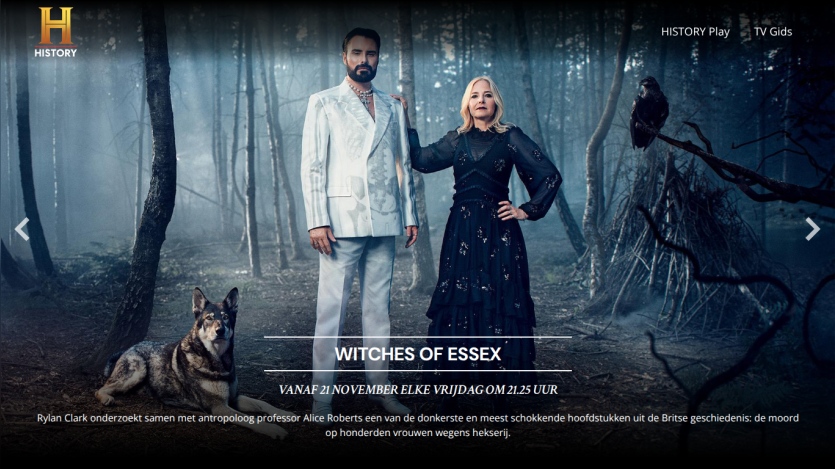 Promotional banner for 'Witches of Essex' TV show airing Fridays at 21:25, featuring two people and a dog in a forest