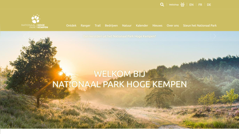 Welcome message and navigation for Nationaal Park Hoge Kempen with a sunrise landscape background