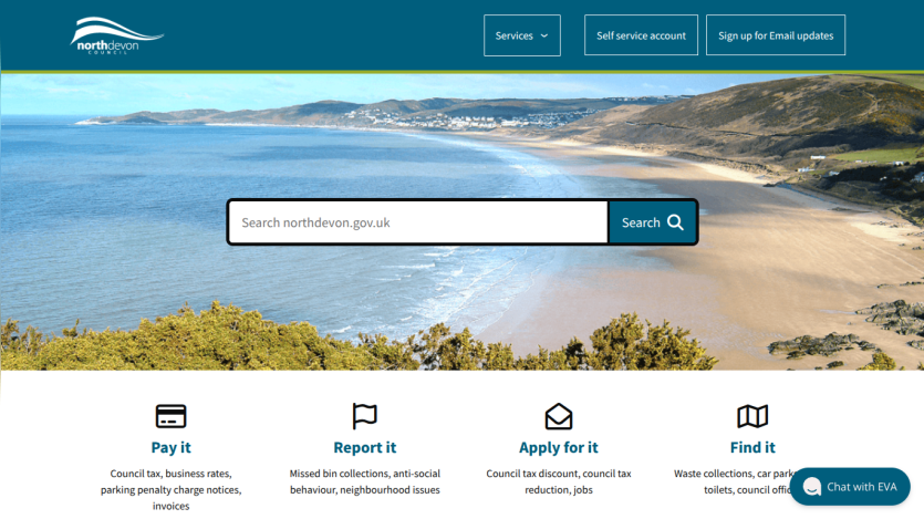 North Devon Council website with search bar over coastal beach hero image and service options to pay, report, apply, or find information.