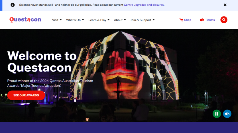 Questacon homepage with navigation, announcement of 2024 Qantas Australian Tourism Award, and night projection on building.