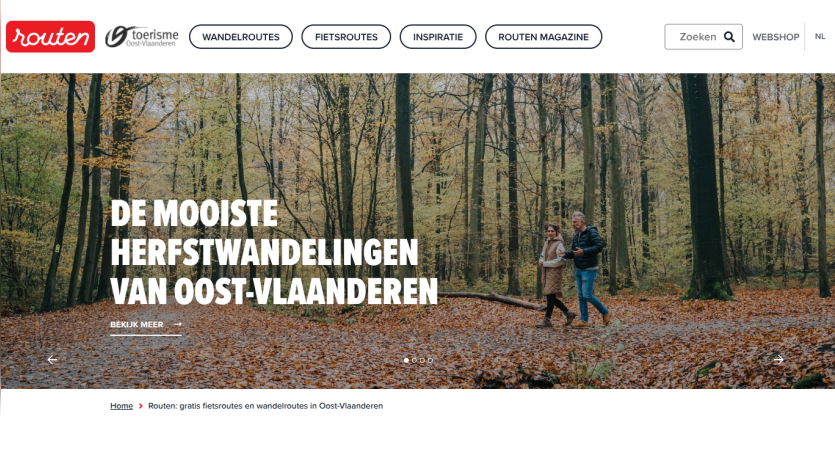 Website header with navigation and hero section promoting autumn walks in East Flanders with a forest background and two people walking