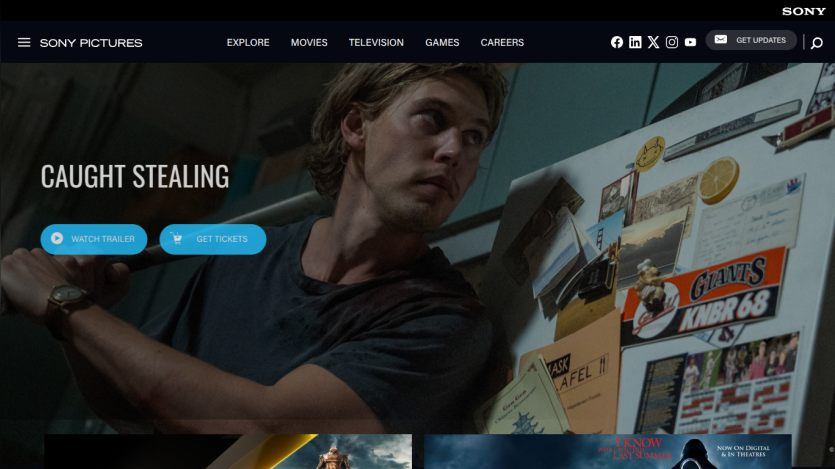 Homepage featuring 'Caught Stealing' with options to watch trailer or buy tickets.
