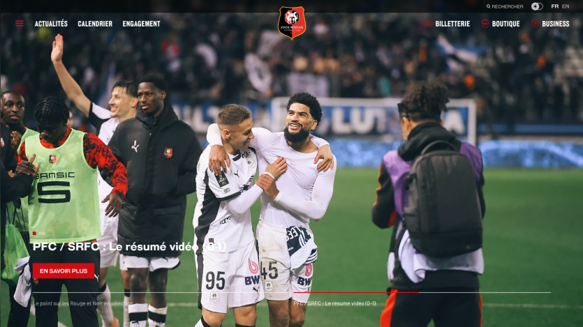 Football players celebrating on the field with score and match details overlay