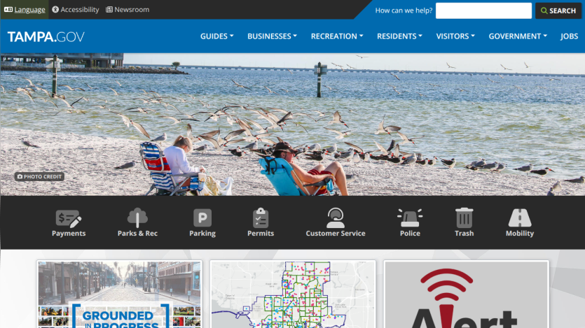 Tampa.gov homepage featuring beach scene, navigation links, and alert notification.