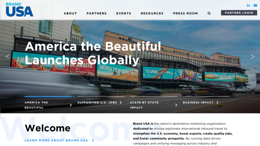 Brand USA homepage featuring America the Beautiful campaign launch with navigation and welcome message