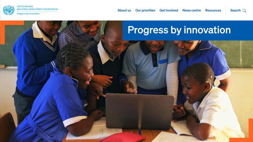 Children collaborating around a laptop, showcasing innovation in education.