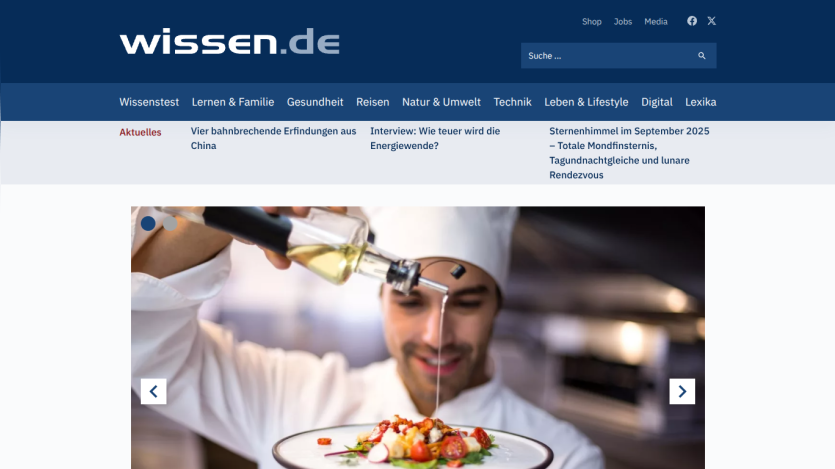 Chef drizzling oil over a gourmet dish in a restaurant setting.