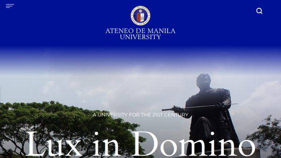 Ateneo de Manila University homepage with logo, tagline 'A University for the 21st Century', and 'Lux in Domino' text over a statue and trees background