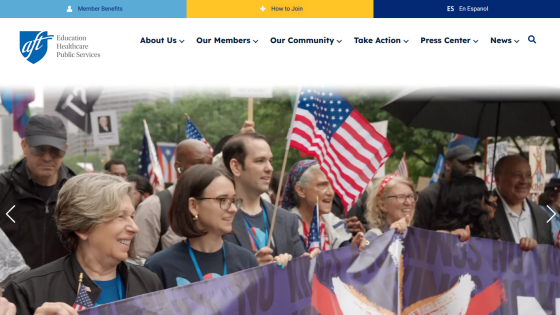 A diverse group of people holding a banner and flags at a public event, with a clear header above.