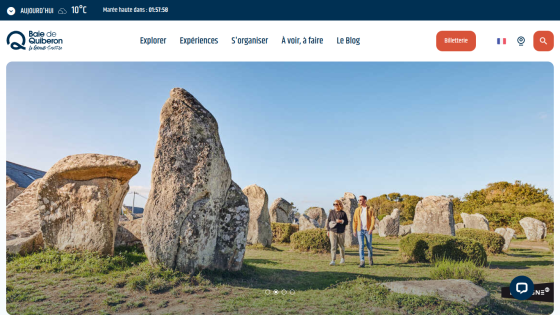 Tourism website header with navigation and hero image of people walking among large standing stones in Baie de Quiberon