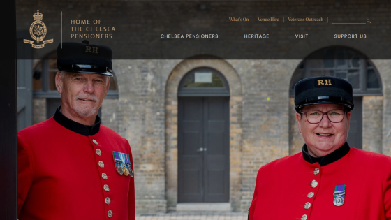 Homepage of Chelsea Pensioners with navigation links and two pensioners in red uniforms in front of a brick building