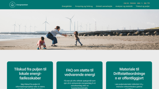 Website promoting local energy initiatives with a family on the beach and wind turbines in the background.