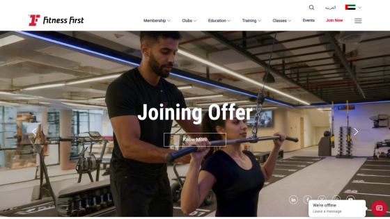 Fitness First gym website showing a joining offer with a trainer assisting a woman in exercise