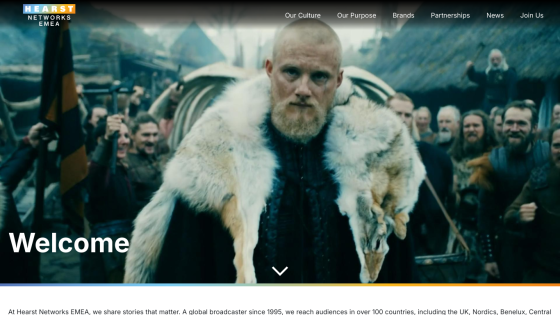 Welcome message with a prominent figure in a fur coat and a crowd in the background.
