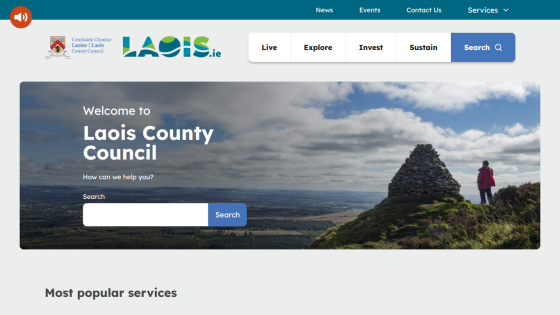 Laois County Council homepage with navigation and search bar over scenic hilltop background.