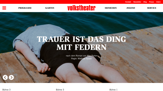Volkstheater website showing a hero image with a person lying on a wooden dock by water and text about a play titled 'Trauer ist das Ding mit Federn'