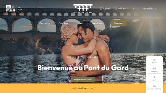 Homepage of Pont du Gard tourism site with a couple embracing under the bridge and options to discover, book, and organize a visit