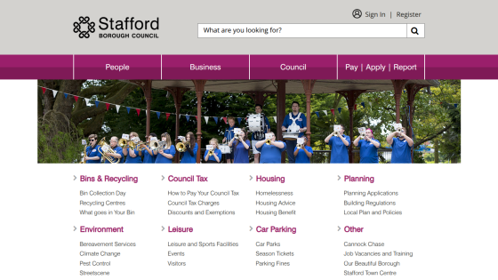 Stafford Borough Council homepage with navigation, search bar, and community service links under a band playing in a park