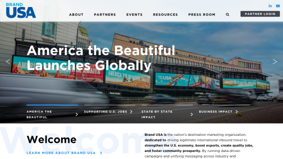 Brand USA homepage featuring America the Beautiful campaign launch with navigation and welcome message
