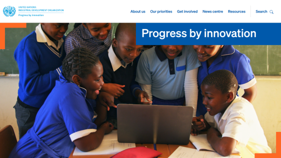 Children collaborating around a laptop, showcasing innovation in education.