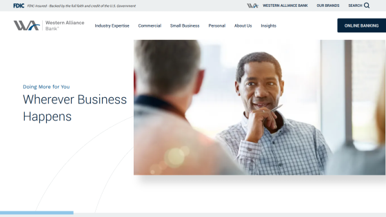 Homepage of Western Alliance Bank featuring a man in conversation with the text 'Wherever Business Happens'.