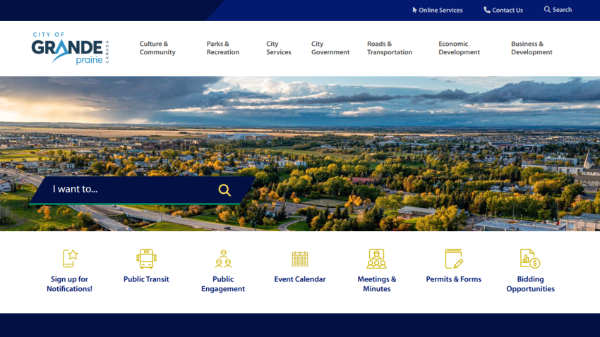 City of Grande Prairie website with navigation links and a scenic aerial view of the city under a cloudy sky