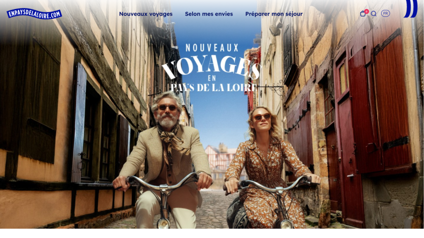 Travel website header with navigation and a hero image of two people cycling in a historic street promoting new trips in Pays de la Loire