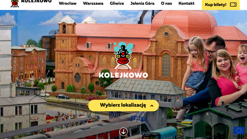 Kolejkowo website hero with model train set and family, featuring a location selection button