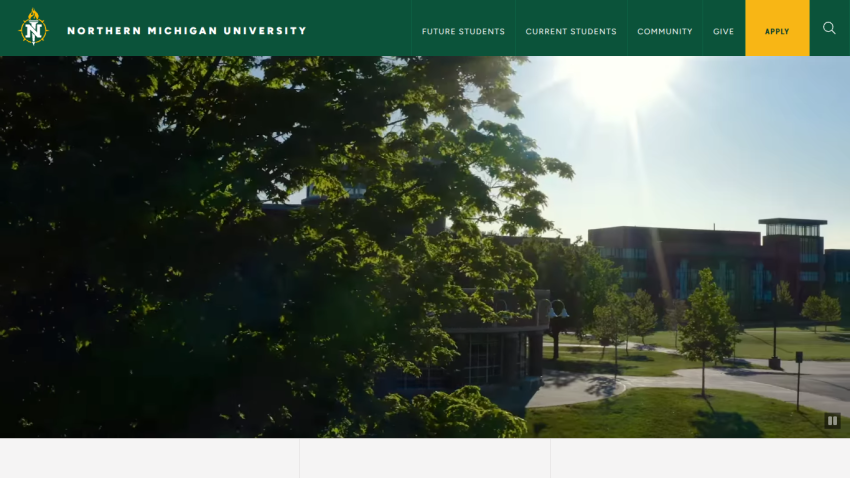 Northern Michigan University campus view with buildings and greenery in sunlight.