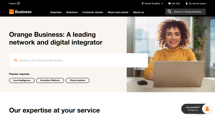 Homepage of Orange Business featuring a search bar and a smiling woman at a desk.