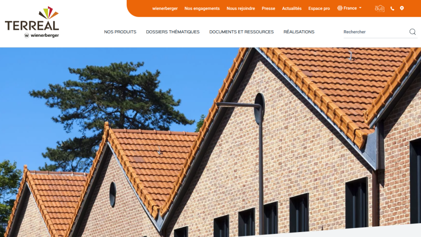 Terreal website header with navigation and hero image showing houses with terracotta tiled roofs under a clear blue sky