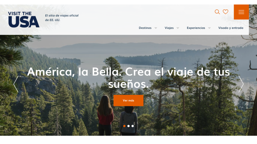 Official USA travel site in Spanish with a scenic forest and lake view, inviting to create your dream trip