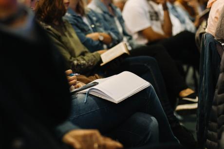 A photo from Victory Church, Jeffreys Bay, South Africa, where devotees are attending a sermon with notebooks and bibles in their hands.