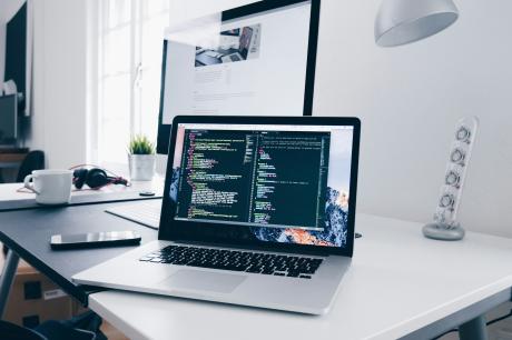 A macbook with lines of code in a termial window